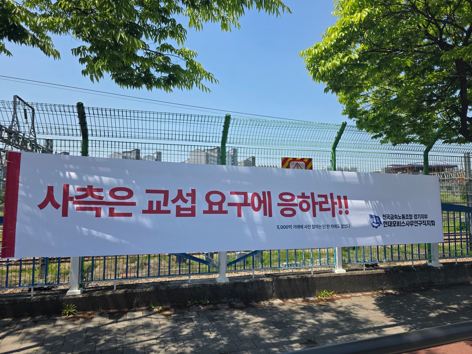 현수막: 사측은 교섭 요구에 응하라!!