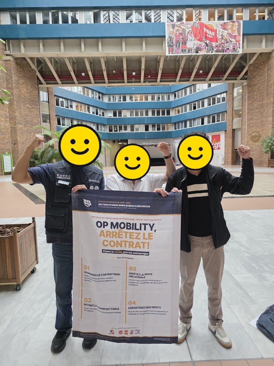 프랑스 CGT 회관에서 우리 지회 집행부와 CGT 금속노련 동지가 ‘OP MOBILITY, ARRÊTEZ LE CONTRAT!’ 현수막을 함께 들고 주먹을 든 모습