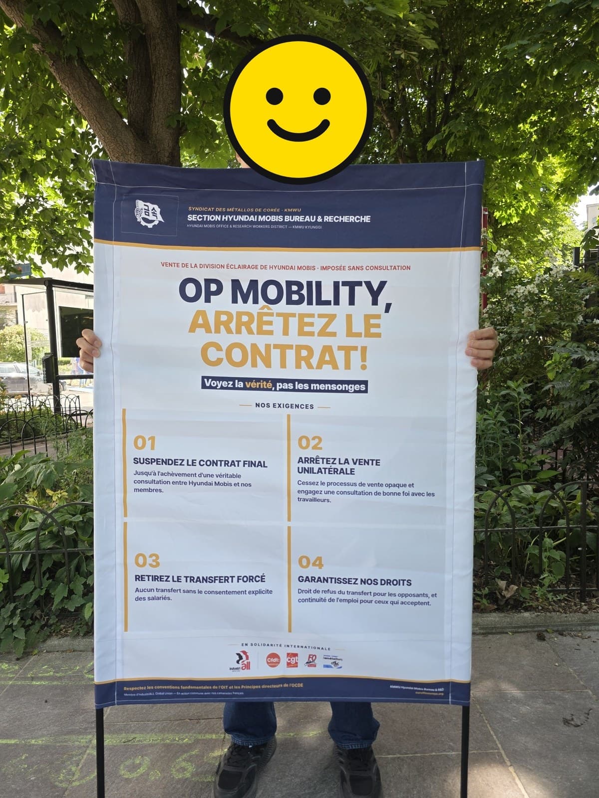 “OP MOBILITY, ARRÊTEZ LE CONTRAT!”와 네 가지 요구(NOS EXIGENCES)가 프랑스어로 적힌 현수막 전문