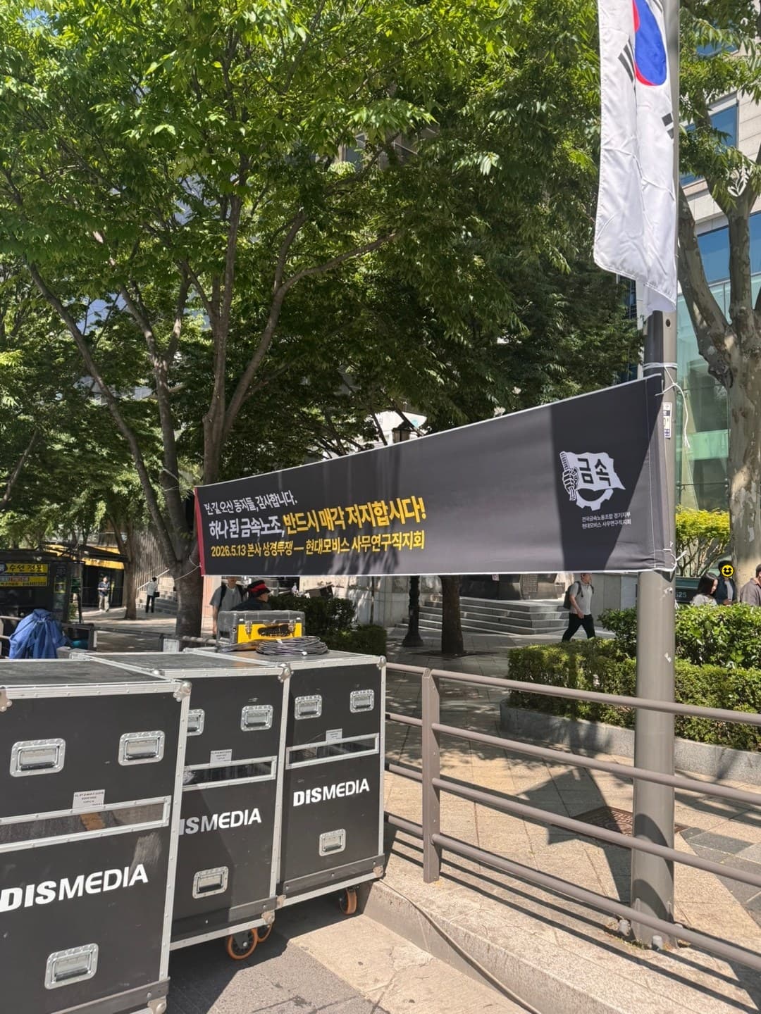 태극기 옆에 걸린 환영 현수막 — 「2026. 5. 13 본사 상경투쟁 · 현대모비스 사무연구직지회」